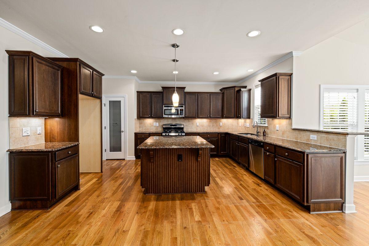 A kitchen with dark wooden cabinets and a stone-topped island