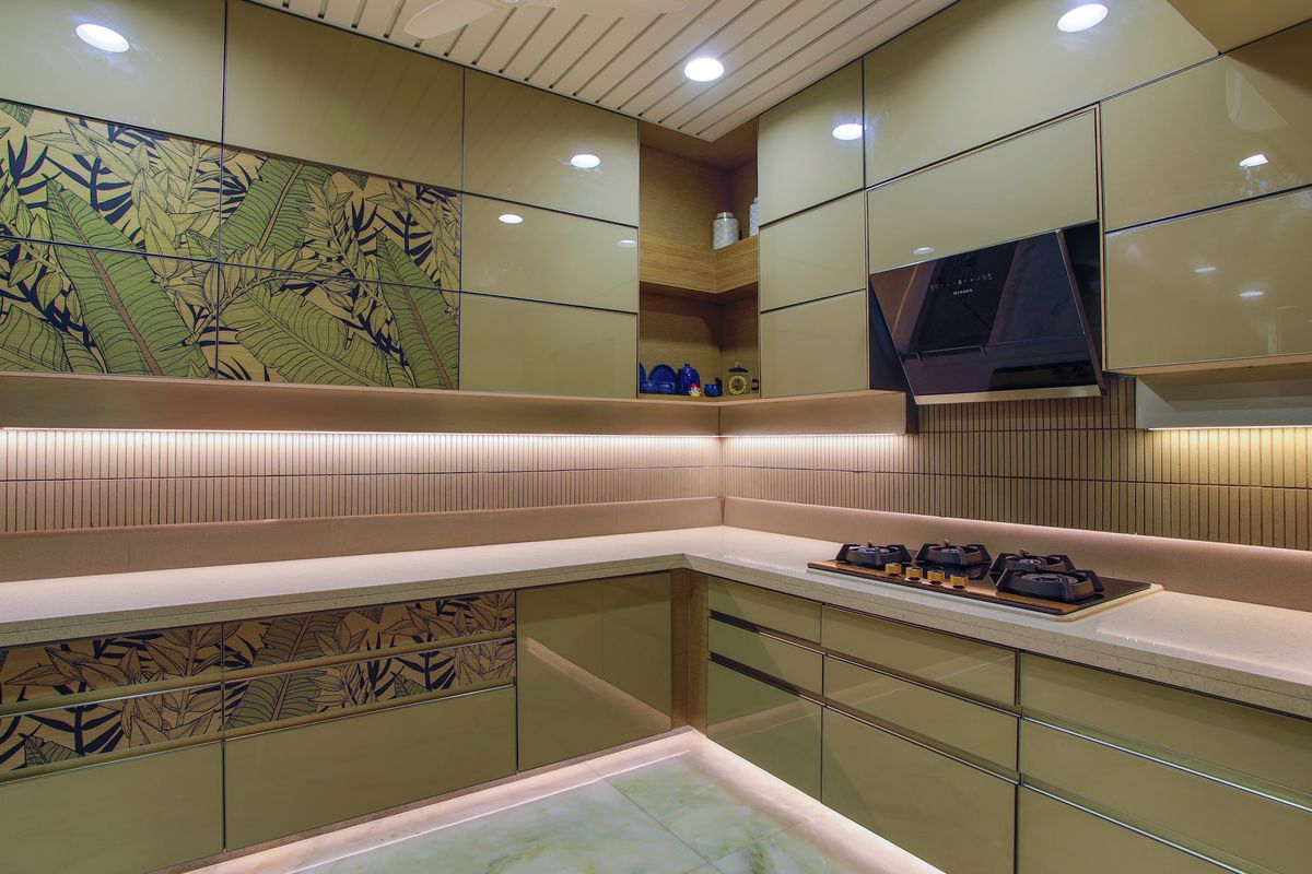 A kitchen with green gloss fronts and a floral niche panel