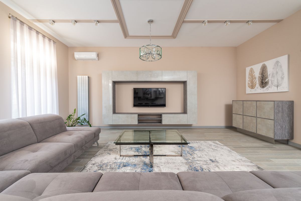 A living room with a grey sofa and a wall unit